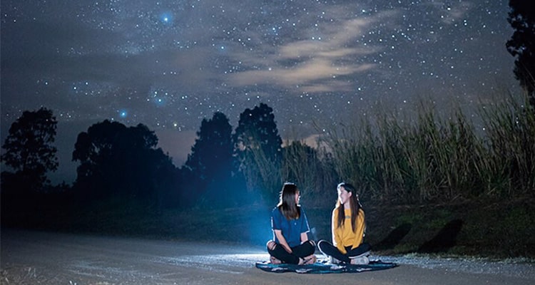 綺麗な夜空を背景に語り合う学生たち